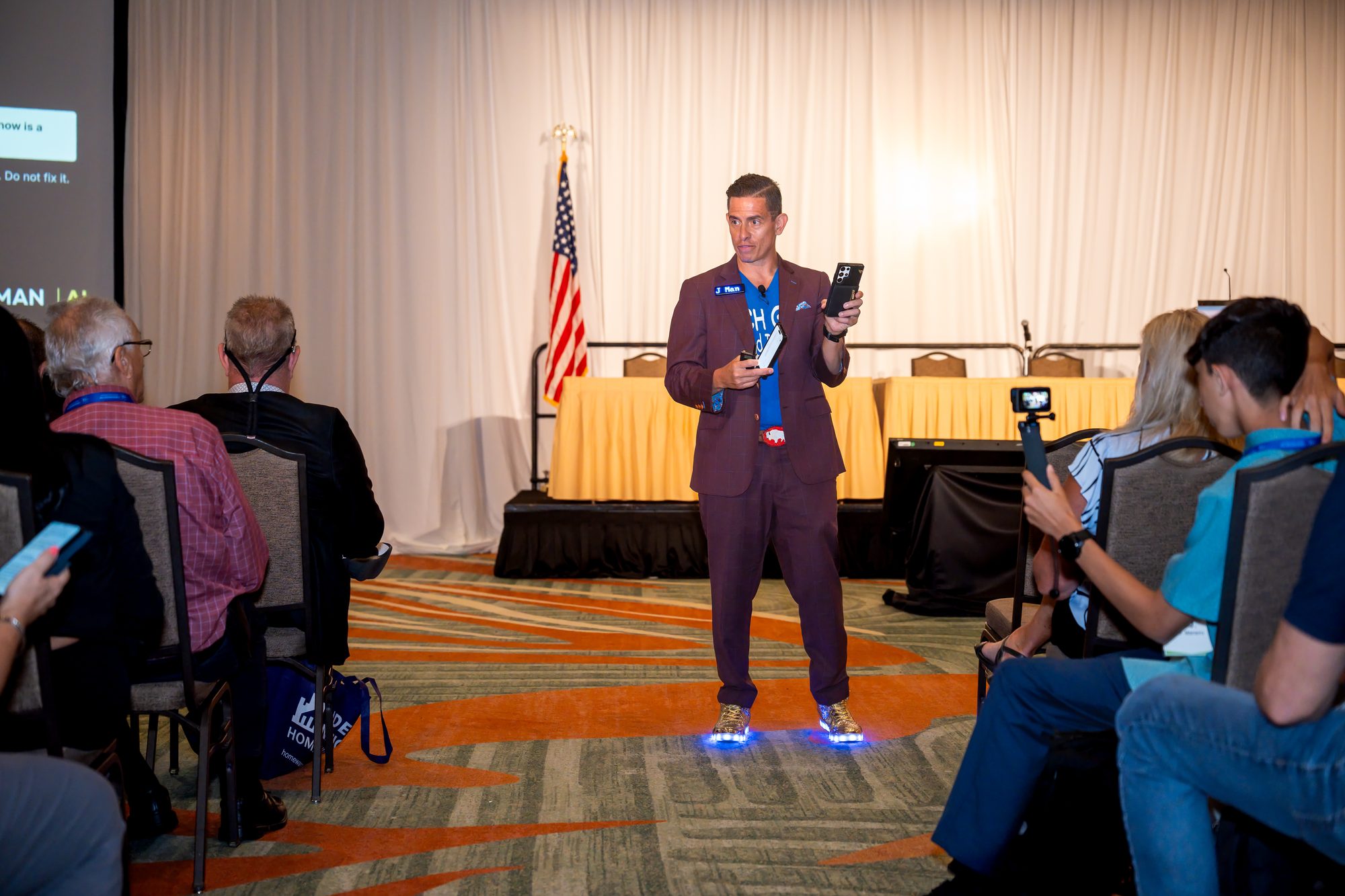 JMan demonstrating an AI prompt on a phone during his real estate AI keynote at the Florida Realtors Convention