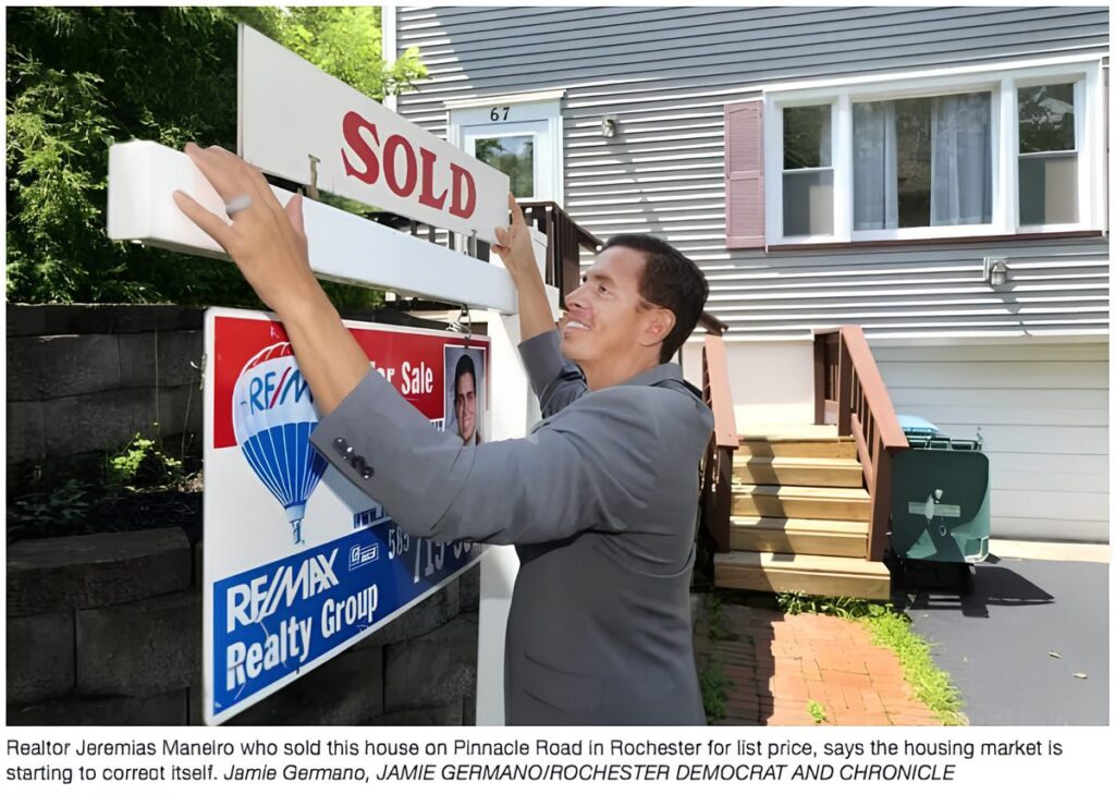 JMan putting a SOLD sign up on a house on Pinnacle Road in Rochester, from the Democrat and Chronicle